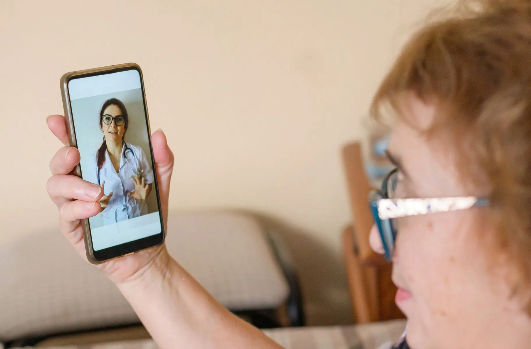 Imagem mostra senhora idosa segurando um smartphone