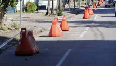 Imagem mostra uma rua de Curitiba com cones para organização do trânsito.