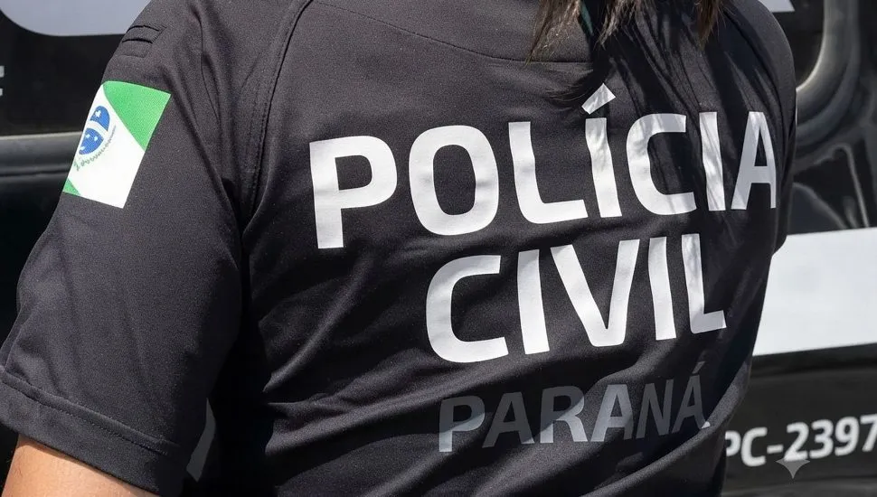imagem mostra as costas de uma policial da Polícia Civil com uma camiseta com o nome da força de segurança