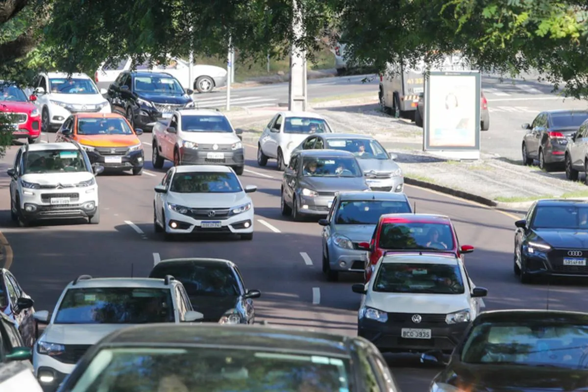 Imagem mostra carros circulando em uma rua de Curitiba.