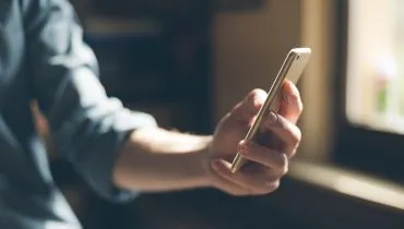 imagem mostra pessoa segurando celular