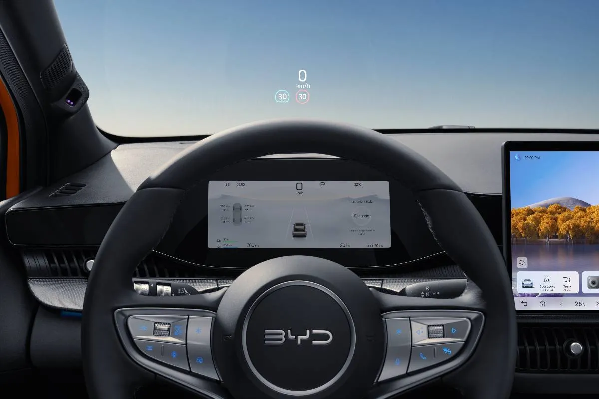 Imagem mostra a interna do novo BYD Dolphin G com detalhe para o volante e o painel de instrumentos.