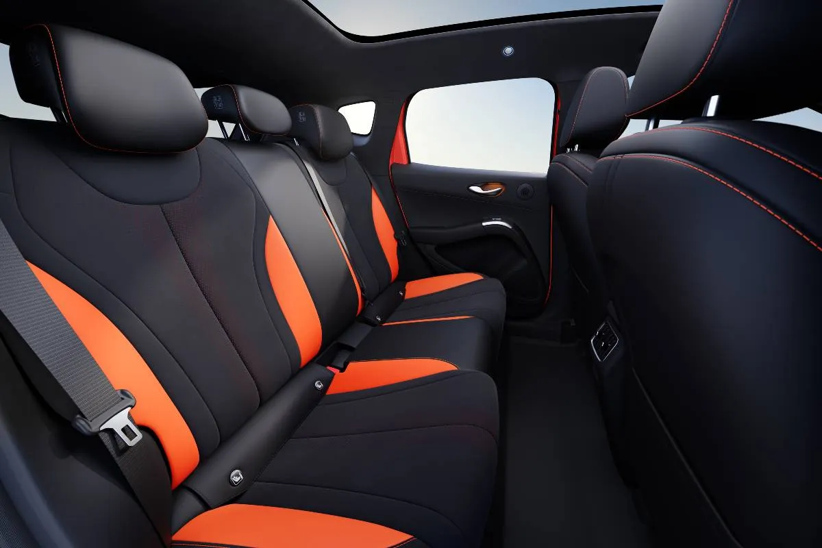 Imagem mostra a interna do novo BYD Dolphin G com o teto solar e detalhes em laranja
