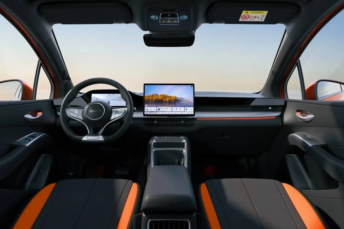 Imagem mostra a interna do novo BYD Dolphin G com detalhes em laranja.