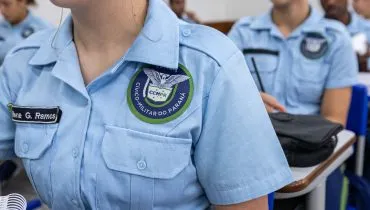 A imagem mostra uma aluna da rede estadual do Paraná, onde o modelo de colégios cívico-militares já funciona. Em Curitiba, a eventual implantação nas escolas municipais ainda será definida após consultas à comunidade escolar.
