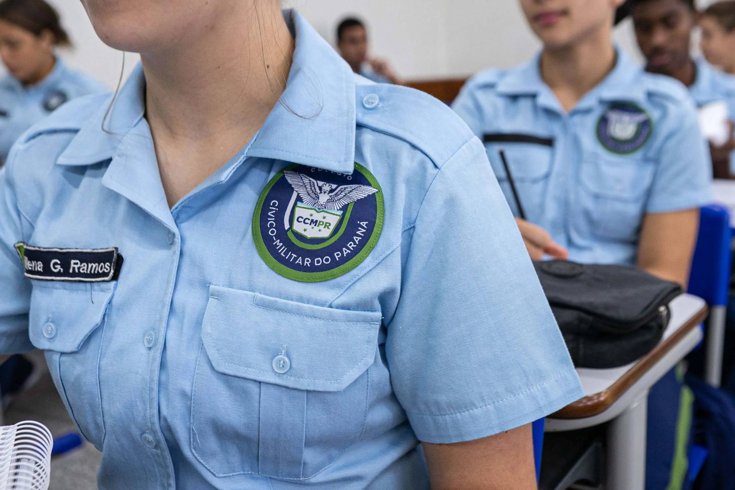 A imagem mostra uma aluna da rede estadual do Paraná, onde o modelo de colégios cívico-militares já funciona. Em Curitiba, a eventual implantação nas escolas municipais ainda será definida após consultas à comunidade escolar.