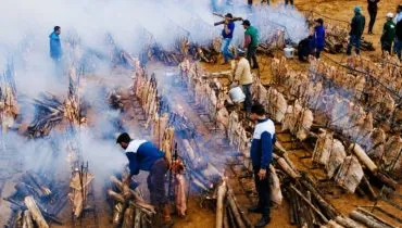 Homens assando muitas costelas fogo de chão ao mesmo tempo / Assafest Curitiba