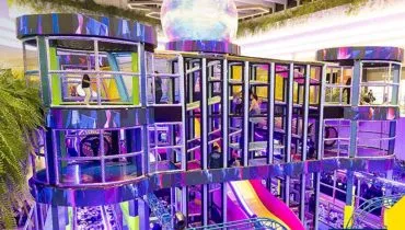 Crianças com TEA se divertindo em parque de diversões neon no Shopping Jockey Plaza.