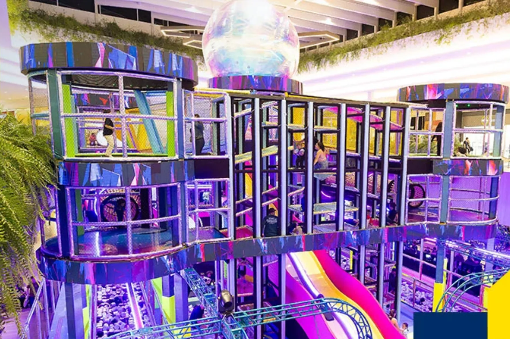 Crianças com TEA se divertindo em parque de diversões neon no Shopping Jockey Plaza.