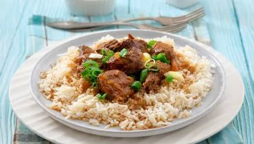 Imagem mostra um prato com picadinho de carne e arroz.