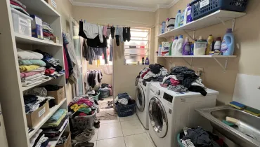 Lavanderia abarrotada de roupa para lavar por cima da máquina, no chão, em cestos, etc. / lavanderia por assinatura