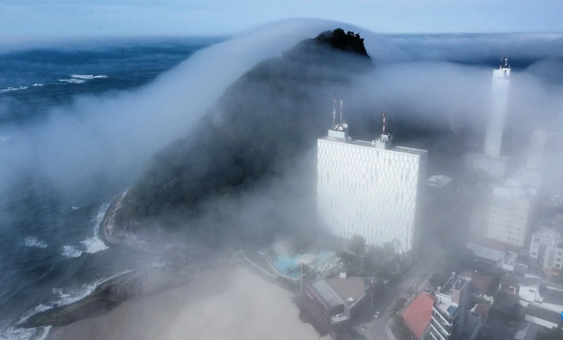 Imagem mostra orla de Matinhos, no Paraná, tomada por neblina/nevoeiro vindo do mar