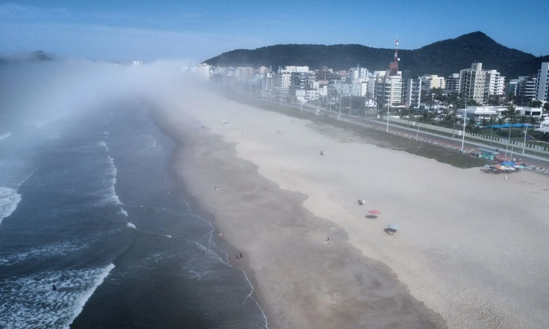 Imagem mostra orla de Matinhos, no Paraná, tomada por neblina/nevoeiro vindo do mar