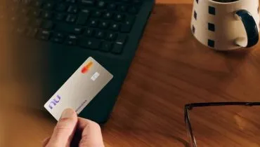 Imagem mostra uma pessoa segurando o cartão da nova modalidade do Nubank, o Croma.