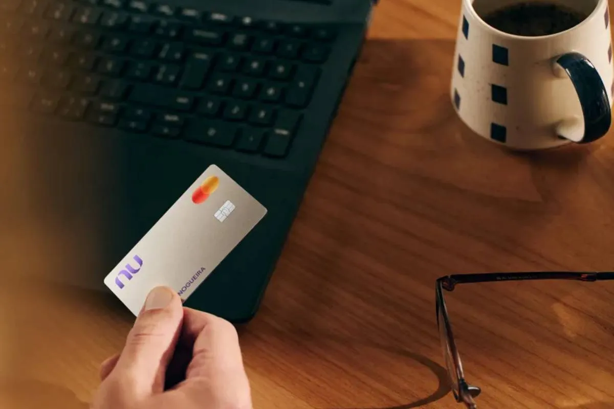 Imagem mostra uma pessoa segurando o cartão da nova modalidade do Nubank, o Croma.