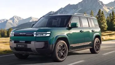 Imagem mostra a frente e a lateral do SUV BYD TI 7 na cor verde.