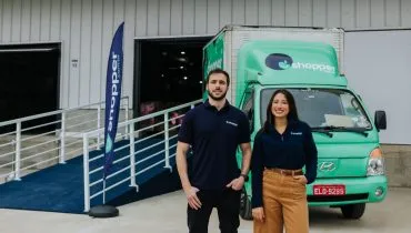 Mercado 100% online / home e mulher em frente a caminhão verde e barracão usado como dark store