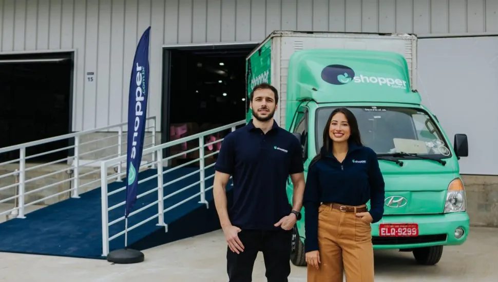 Mercado 100% online / home e mulher em frente a caminhão verde e barracão usado como dark store