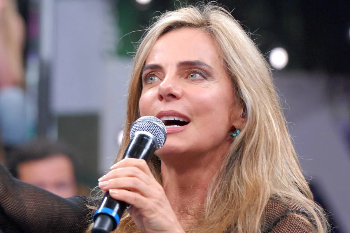 Imagem mostra Bruna Lombardi com um microfone nas mãos.