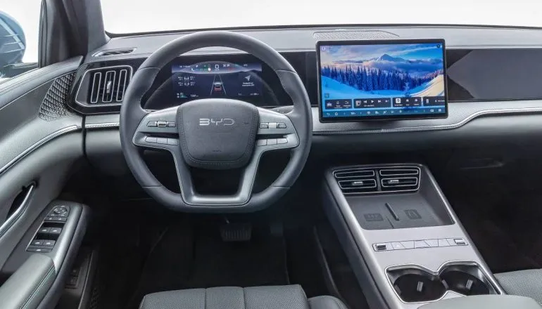 Imagem mostra o painel do novo BYD Song Pro Flex, com foco no volante e carregadores.