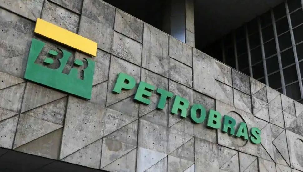 Imagem mostra a fachada da uma unidade da Petrobras, com letras em verde coladas em uma parede de pedra. Há um detalhe em amarelo em cima do "BR".