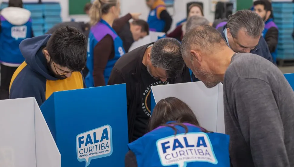 A imagem mostra pessoas votando prioridades para o orçamento na Rua da Cidadania Boa Vista.