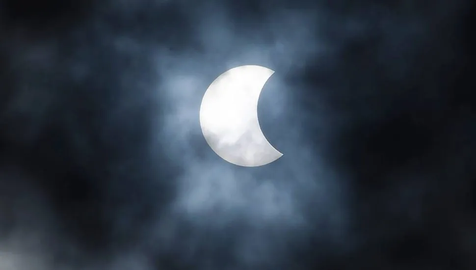 Imagem mostra um eclipse solar, com o sol sendo parcialmente coberto pela passagem da Lua.