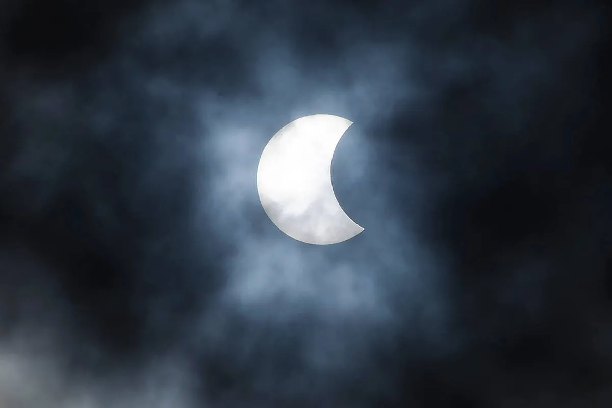 Imagem mostra um eclipse solar, com o sol sendo parcialmente coberto pela passagem da Lua.