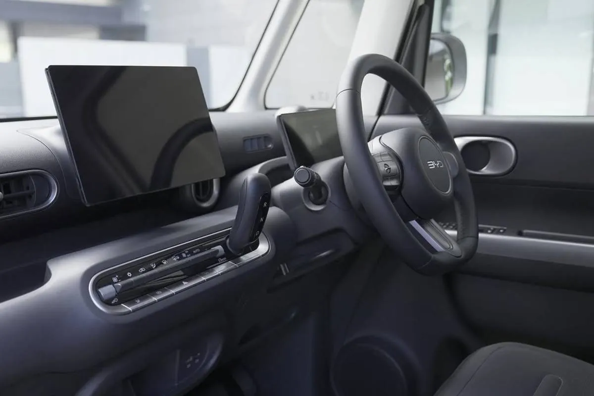 Imagem mostra a interna do novo BYD Racco. Detalhe para o volante e cluster.