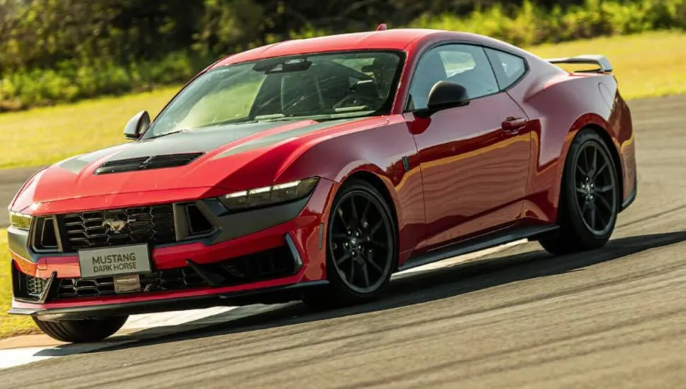 Imagem mostra um Ford Mustang 2026 vermelho durante uma curva em uma pista de corrida.