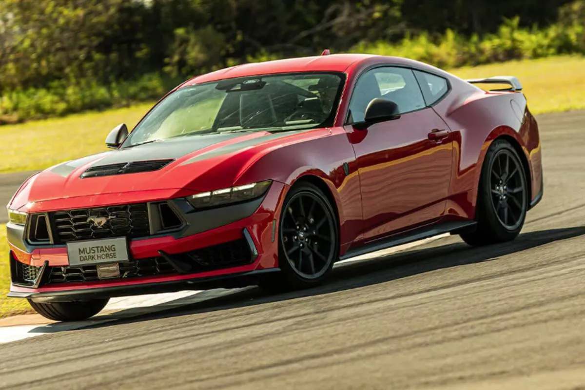 Imagem mostra um Ford Mustang 2026 vermelho durante uma curva em uma pista de corrida.