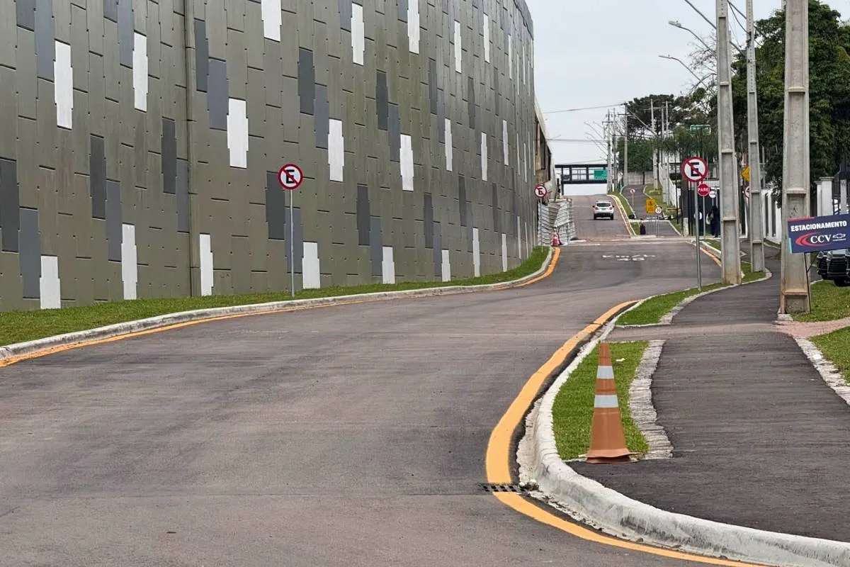 Imagem mostra um novo acesso em Curitiba que foi liberado no bairro Tarumã. A imagem mostra uma pista de asfalto ao lado de um paredão do viaduto pintado de cinza com bolas brancas e pretas.