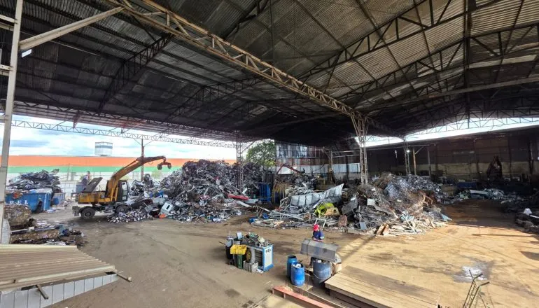 Reciclagem em Curitiba / barracão de recicláveis com pilhas de metais no chão do barracão