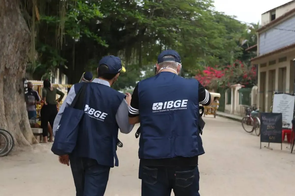 Imagem mostra dois servidores do IBGE em atuação em uma praça de uma cidade.