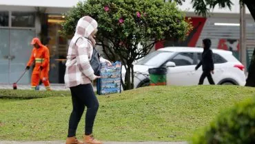 Imagem mostra uma pessoa com muito frio, com blusa e gorro.