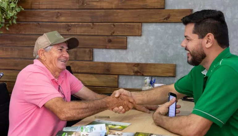 Imagem mostra um idoso em uma conversa com um bancário.