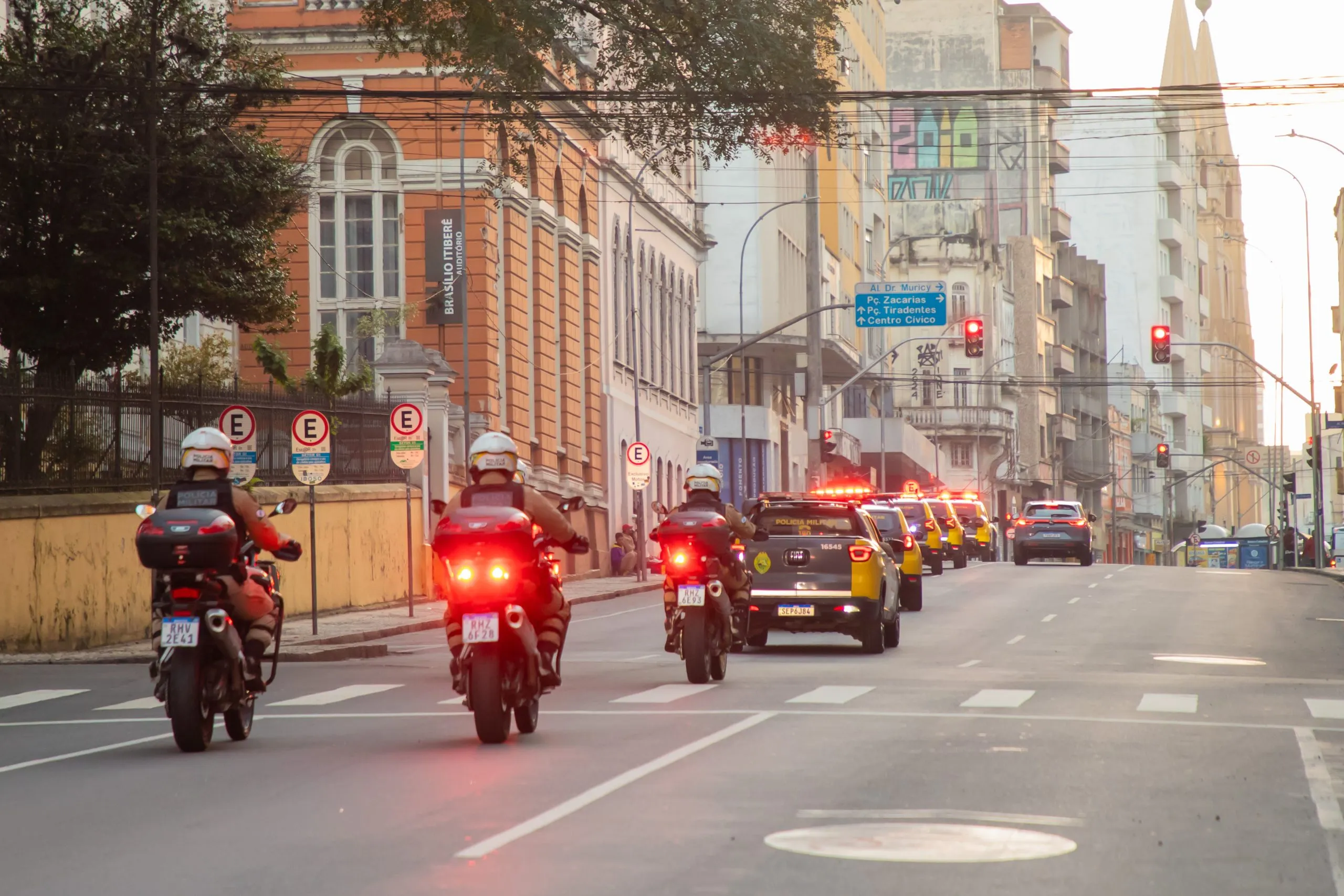 A imagem mostra motos e viaturas da Polícia Militar e da Guarda Municipal em rua do centro de Curitiba.