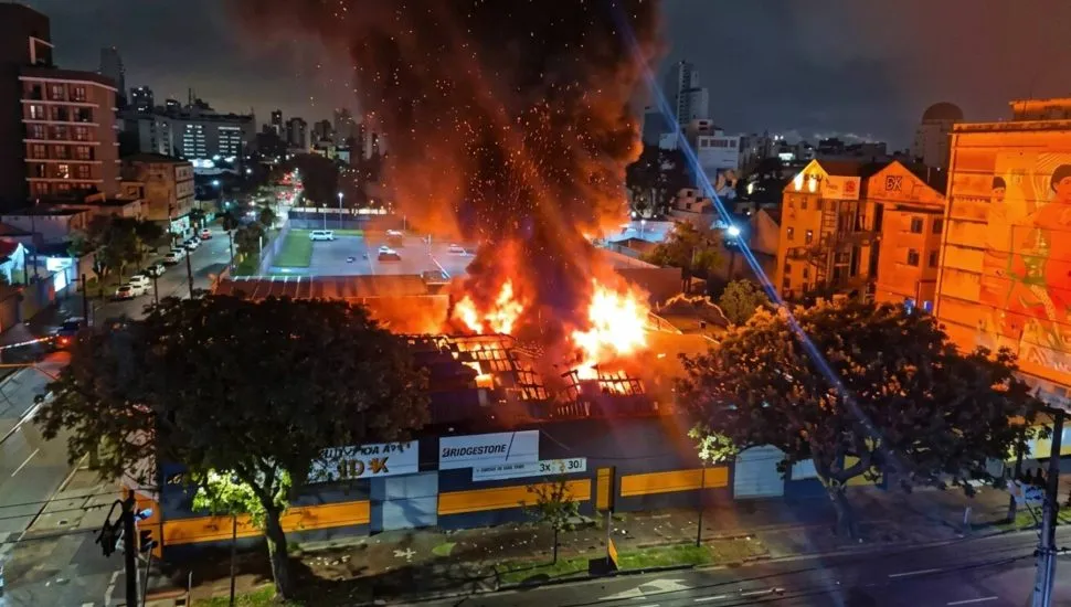 Imagem mostra um incêndio destruindo um barracão de pneus em Curitiba.