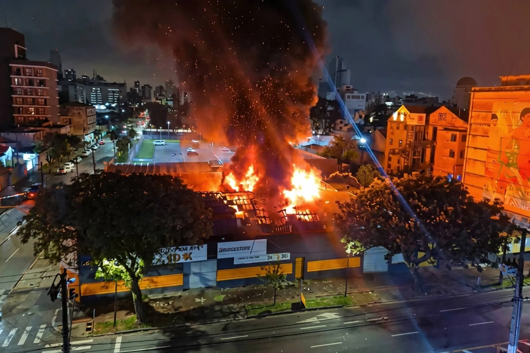 Imagem mostra um incêndio destruindo um barracão de pneus em Curitiba.