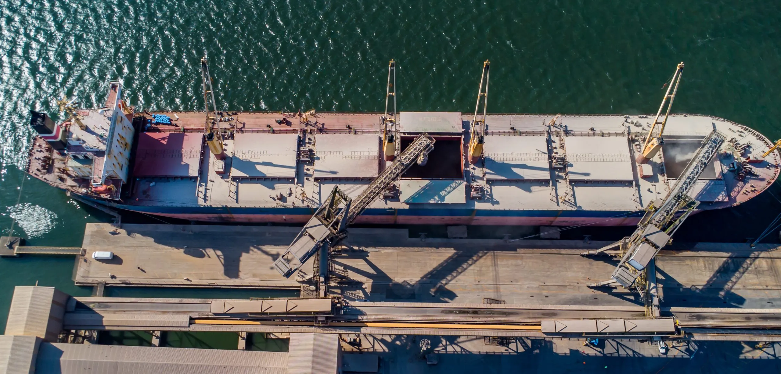 Rocha terminal Paranaguá / vista de cima de navio atracado, descarregando grãos nas esteiras