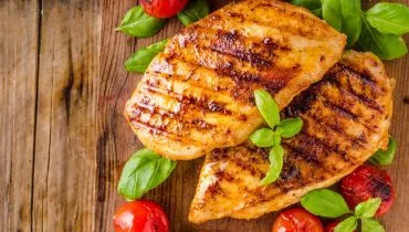 Imagem mostra dois bifes de frango grelhados suculentos prontos para servir.