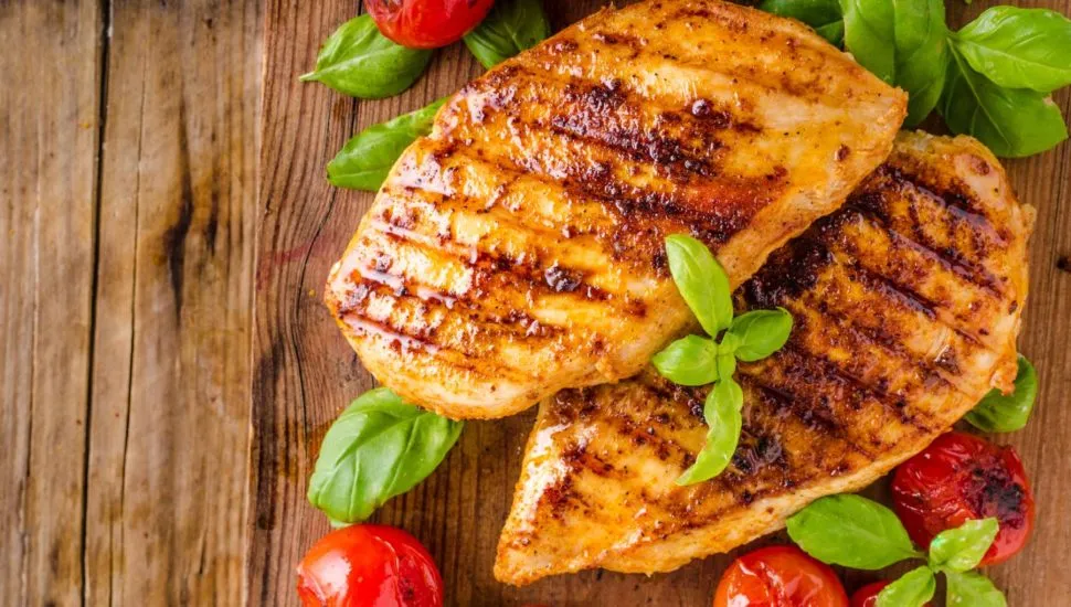 Imagem mostra dois bifes de frango grelhados suculentos prontos para servir.