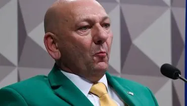 Imagem mostra o empresário Luciano Hang, o "Véio da Havan, com um terno verde com gravata amarela.