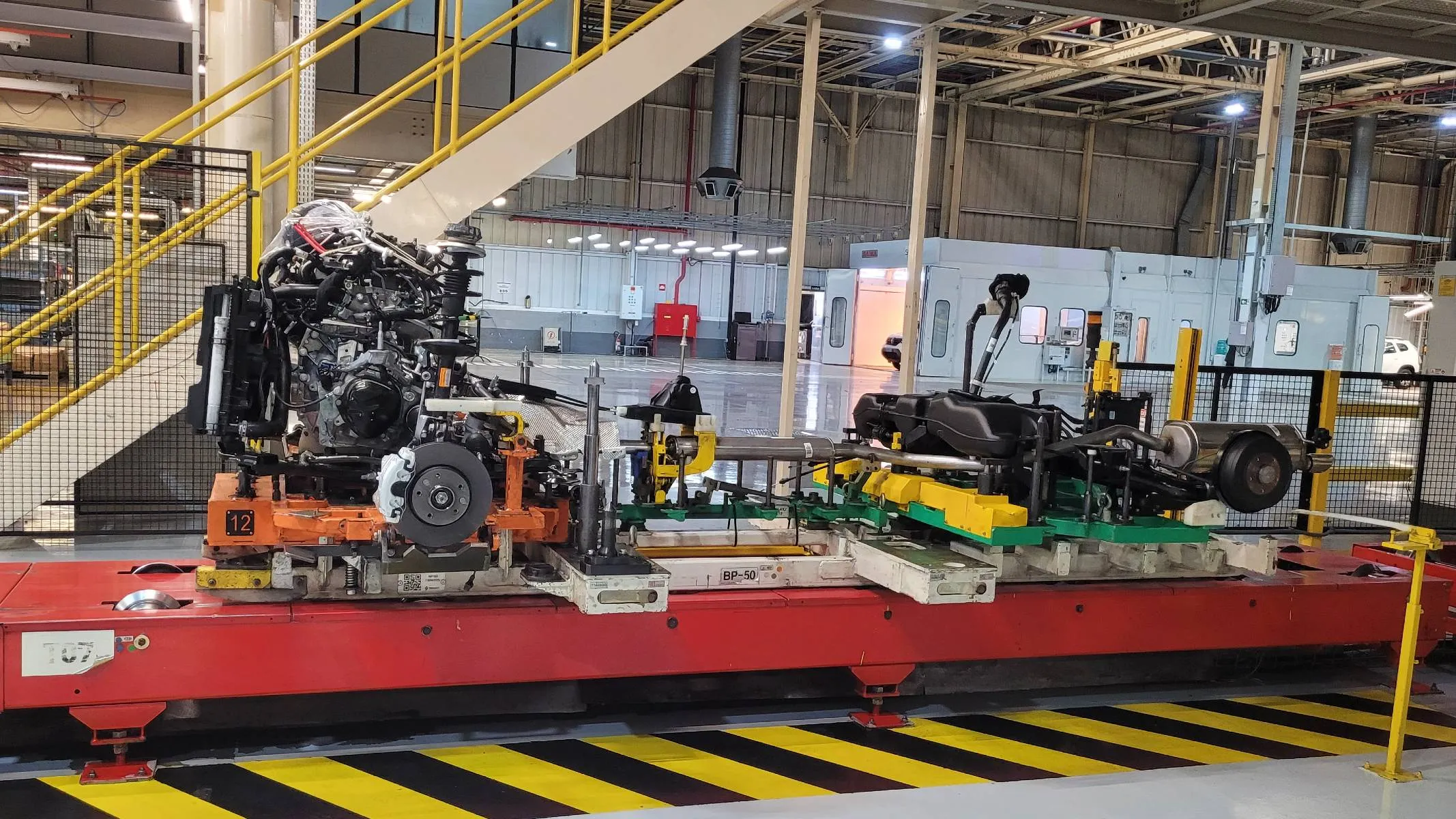 Imagem mostra a fábrica da Renault Geely Brasil instantes antes do casamento entre chassis e carroceria.