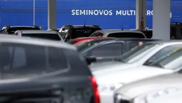 Imagem mostra uma revenda de carros usados.