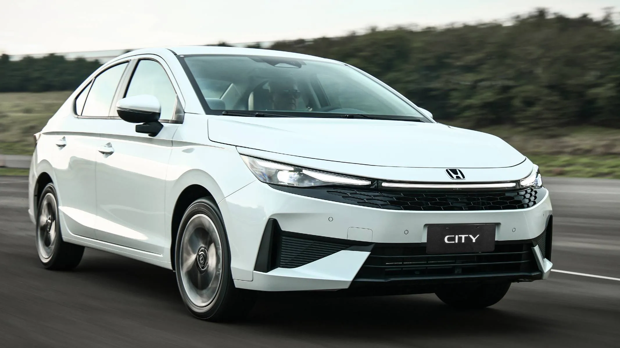 Honda City Sedan Touring 2027 - A dianteira do City Sedan Touring traz faróis Full LED com DRL bipartido e barra de LED conectando o conjunto óptico, novo logotipo 2D, grade colmeia e rodas de liga leve de 16” com acabamento na cor preta.