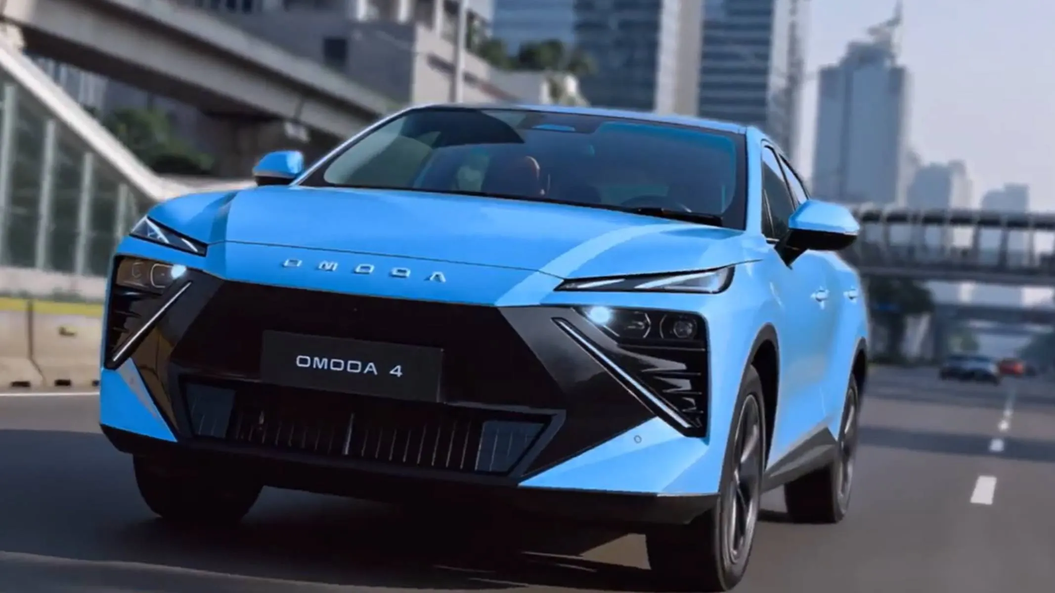 Omoda 4 dianteira destalhes grade e farol na cor azul na rua - Omoda 4: o novo SUV eletrificado do Chery International Group que chega ao Brasil no plano de expansão da marca até 2027. Destaque para o design moderno, 19 funções de assistência ADAS e o eficiente sistema de motorização SHS (Super Hybrid System).