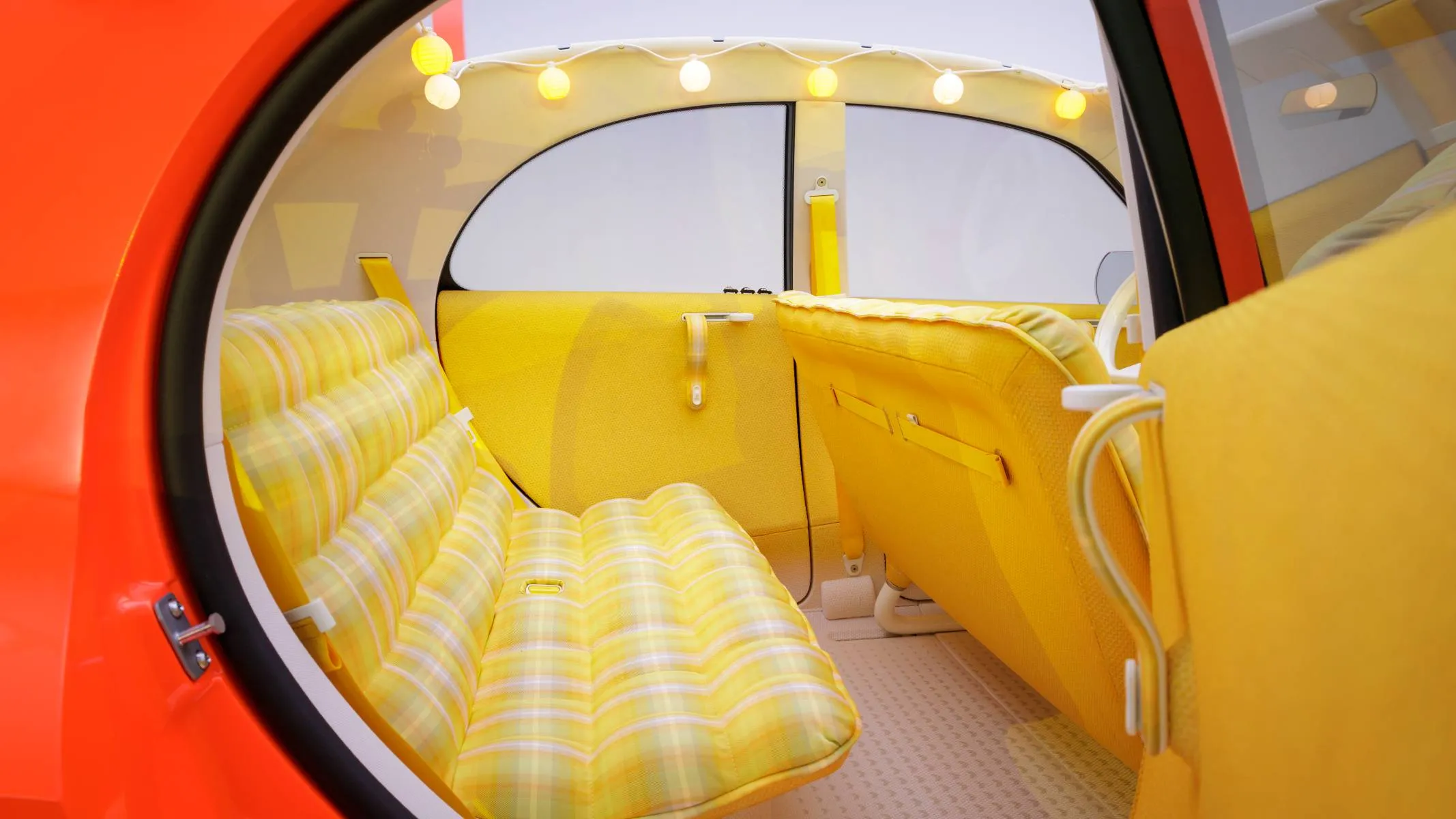 Citroen 2 CV interna amarelo- Detalhe dos assentos traseiros com padrão xadrez em tom amarelo e tecnologia Citroën Advanced Comfort. O revestimento interno do protótipo elétrico resgata e reinterpreta o clássico tecido tartan do veículo original.