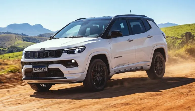 Imagem mostra o novo Jeep Compass blackhawk externa dianteira branco na estrada de terra