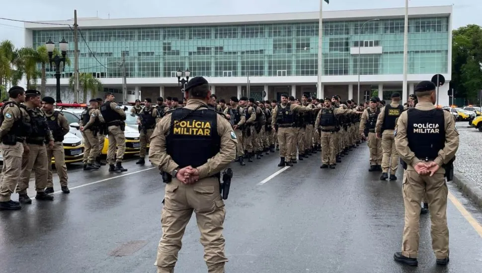A imagem mostra policiais militares em formação em frente ao Palácio Iguaçu.